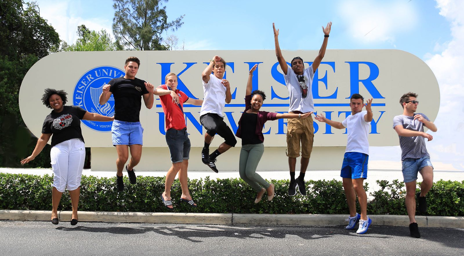 Keiser Students jumping in front of Keiser University sign